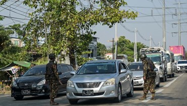 عناصر من قوات الأمن البورمية يدققون في السيارات على طريق في يانغون (2 نيسان 2024، أ ف ب). 