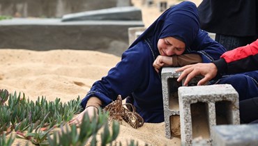 امرأة تبكي عند قبر أحد أحبائها في مقبرة برفح في جنوب قطاع غزة، في بداية عيد الفطر (10 نيسان 2024، أ ف ب). 