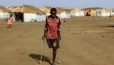 أطفال فرّوا من ولايتي الخرطوم والجزيرة في السودان، بالقرب من مخيّم للنازحين (أ ف ب). 