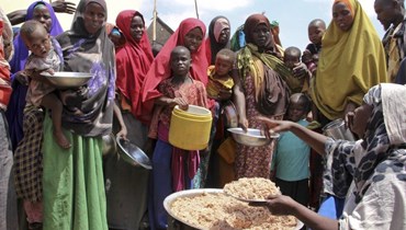صوماليون نزحوا بسبب الجفاف، يتلقون مواد غذائية في مخيمات موقتة في منطقة تابيلها على مشارف مقديشو (30 آذار 2017، أ ب). 
