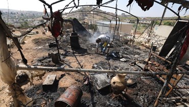 فلسطيني يتفقّد الأضرار التي لحقت بممتلكاته في قرية المغير بالقرب من رام الله في الضفة الغربية (13 نيسان 2024 - أ ف ب).