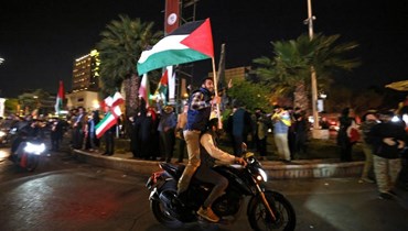 متظاهرون يلوحون بالأعلام الإيرانية والفلسطينية خلال تجمعهم في ساحة فلسطين في طهران (14 نيسان 2024، أ ف ب). 