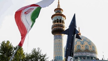 العلم الإيراني وإلى جانبه صاروخ. 