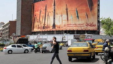 جدارية كبيرة في إيران تحمل صورة أسلحة وعنوان "الوعد الصادق" (أ ف ب).