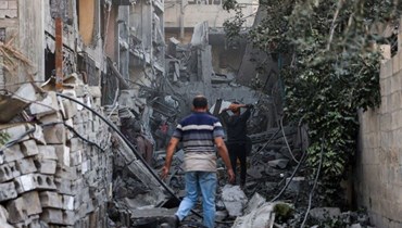 فلسطينيون يتفقدون أنقاض مبنى بعد القصف الإسرائيلي على حي الدرج في مدينة غزة (16 نيسان 2024 - أ ف ب).