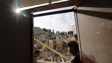 فلسطينيون يتفقدون أنقاض مبنى أصيب في قصف إسرائيلي في رفح بجنوب قطاع غزة (21 نيسان 2024، أ ف ب).
