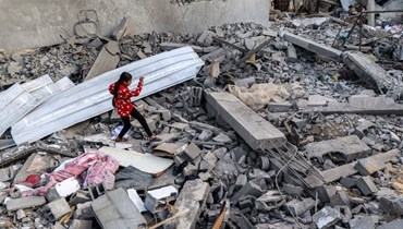 فتاة تمشي وسط الأنقاض في رفح بجنوب قطاع غزة في (24 نيسان 2024 - أ ف ب).
