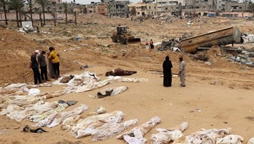أشخاص يتجمعون بالقرب من الجثث المصطفة لتحديد هوياتهم بعد اكتشافها من مقبرة جماعية تم العثور عليها في مجمع ناصر الطبي في جنوب قطاع غزة (25نيسان 2024 - أ ف ب).