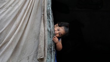 طفل فلسطيني داخل خيمة في منطقة تؤوي النازحين في رفح (أ ف ب). 
