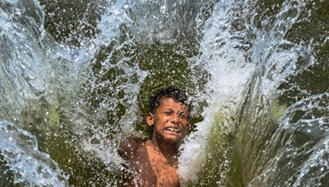 طفل يغطس في بحيرة في دكا (29 نيسان 2024، أ ف ب). 