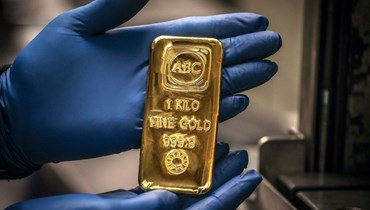 عامل يعرض سبيكة من الذهب بوزن كيلوغرام واحد في ABC Refinery في سيدني بأوستراليا (5 آب 2020ـ أ ف ب).