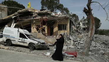 امرأة تقف أمام منزل دمّرته غارة إسرائيلية في بلدة حانين (أ ف ب). 