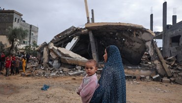 فلسطينيّون يتفقّدون الدمار الذي أعقب الغارات الإسرائيلية الليلية على رفح (أ ف ب). 