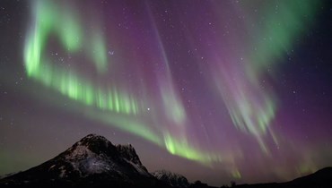 تظهر هذه الصورة الأضواء الشمالية (Aurora Borealis) فوق الجبل في Utakleiv في (3 آذار 2024 في جزر لوفوتين - أ ف ب).