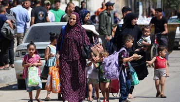 نساء وأطفال فلسطينيون يفرون من رفح جنوب قطاع غزة (15 ايار 2024، أ ف ب).