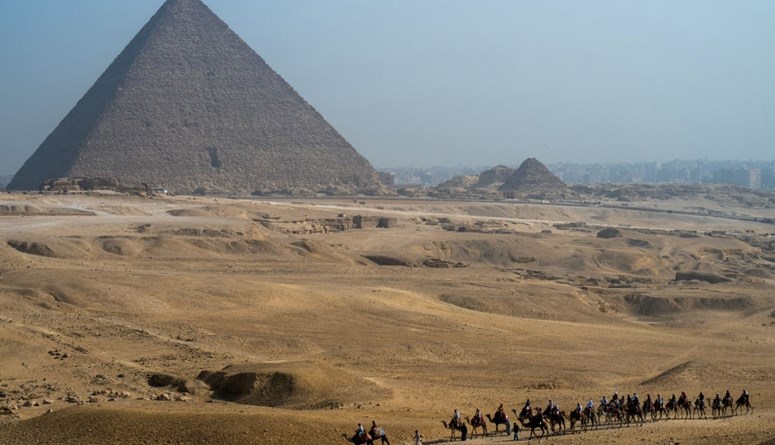 سياح يركبون الجمال بالقرب من الهرم الأكبر في الجيزة في 3 أيار 2024 ( AFP / Jewel SAMAD)
