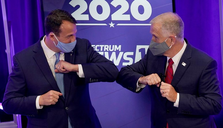 المرشح الديموقراطي كال كانينغهام يصافح منافسه السيناتور توم تيليس بعد مناظرة تلفزيونية في 1 تشرين الأول (أ ب).